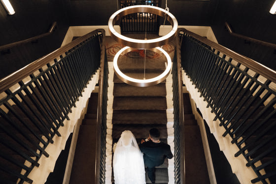 View from above of bride and groom walking up stairs